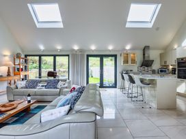 A living room with a sofa and kitchen island at Beachcombers in Marhamchurch