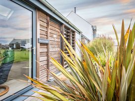 An exterior view of Beachcombers with plants and a sign in Marhamchurch