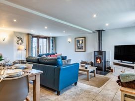 A living room with a sofa and a wood stove at Woodyplatt in Marhamchurch
