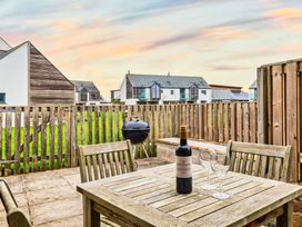 An outdoor area with a table and wine at Woodyplatt in Marhamchurch