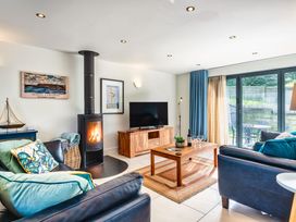 A living room with a fireplace and a television at Chapel Park in Marhamchurch