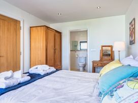 A bedroom with a bed and wardrobe at Chapel Park in Marhamchurch