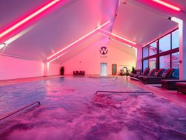 An indoor pool area with lounge chairs at Chapel Park in Marhamchurch