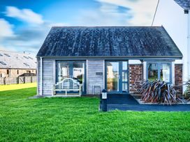 A wooden house with a slate roof and a garden at Little Main in Marhamchurch