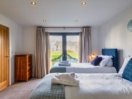 A bedroom with two beds and a chest of drawers at Little Main in Marhamchurch