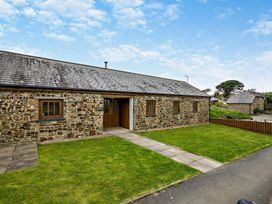 An outdoor view of a stone building with a pathway at Long Down Spa Marhamchurch