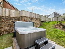 A hot tub with steps in an outdoor area at Long Down Spa in Marhamchurch