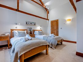 A bedroom with two beds and wooden furniture at Long Down Spa Marhamchurch