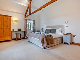 A bedroom with a bed and a wardrobe at Long Down Spa in Marhamchurch