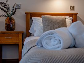 A bedroom with a bed and bedside table at Long Down Spa in Marhamchurch