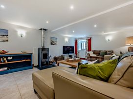 A living room with a stove and sofa at Middle Hill in Marhamchurch