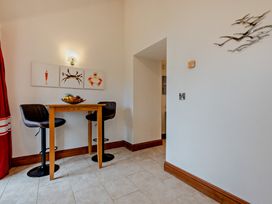 A dining area with a bar table and stools at Middle Hill in Marhamchurch