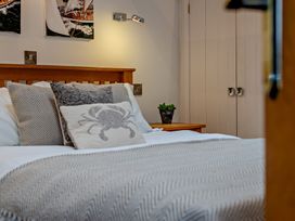 A bedroom with a bed and wall art at Middle Hill in Marhamchurch