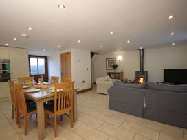 A living room and dining area with a stove and television at Sand Parks Marhamchurch