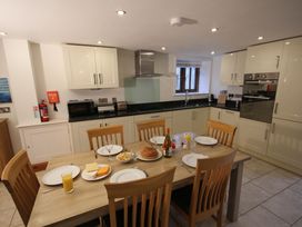 A kitchen with a dining table set for a meal at Sand Parks, Marhamchurch