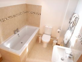 A bathroom with a bathtub, toilet, and sink at Sand Parks in Marhamchurch