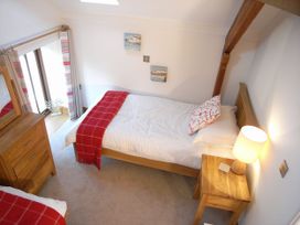 A bedroom with a single bed and a wooden dresser at Sand Parks in Marhamchurch