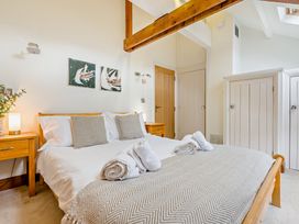 A bedroom with a bed, bedside table, and wardrobe at Sand Parks in Marhamchurch
