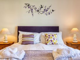 A bedroom with a bed and decorative accessories at Venners in Marhamchurch