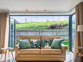 A snug with a sofa and large open doors at Warrens Spa Marhamchurch