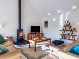 A living room with a fireplace and TV at Warrens Spa in Marhamchurch