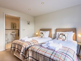 A bedroom with two beds and an adjoining bathroom at Warrens Spa in Marhamchurch