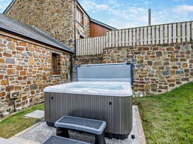 A hot tub with steps in an outdoor area at Warrens Spa in Marhamchurch