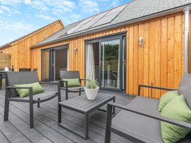 An outdoor patio with chairs and a table at Gwari Spa Barn 2.0 Marhamchurch