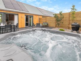 A hot tub in an outdoor space at Gwari Spa Barn 2.0 Marhamchurch