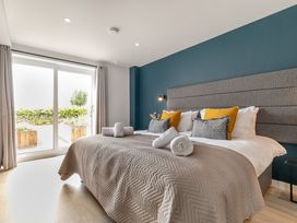 A bedroom with a large bed and pillows at Gwari Spa Barn 2.0 Marhamchurch