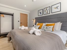 A bedroom with a bed and wardrobe at Gwari Spa Barn 2.0, Marhamchurch