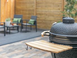 A grill and seating arrangement in an outdoor area at Gwari Spa Barn 2.0, Marhamchurch