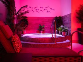 A hot tub surrounded by plants at Gwari Spa Barn 2.0 Marhamchurch