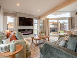 A living room with a sofa and a coffee table at Trelowen 2.0 Spa Marhamchurch