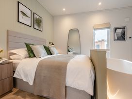 A bedroom with a bed and a bathtub at Trelowen 2.0 Spa in Marhamchurch