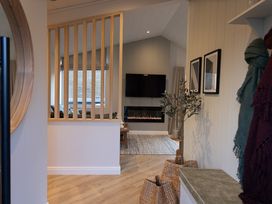 A living room with a television and fireplace at Trelowen 2.0 Spa in Marhamchurch