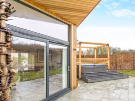 An outdoor area with a hot tub and patio at Trelowen 2.0 Spa in Marhamchurch