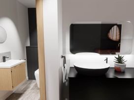 A bathroom with a sink, mirror, and toilet at Arvor Duplex 2.0 Marhamchurch