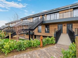 An outdoor view of a wooden building with stairs and pathway at Arvor Duplex 2.0 Marhamchurch