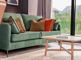 A couch with throw pillows and a coffee table in a living room at Arvor Duplex 2.0 Marhamchurch