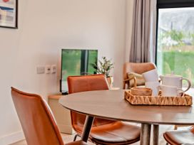 A dining room with a table and chairs at Arvor Duplex 2.0 in Marhamchurch