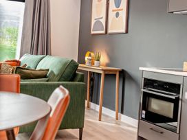 A living room with a sofa and table at Arvor Duplex 2.0 in Marhamchurch