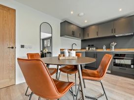 A dining room with a table and chairs at Arvor Duplex 2.0 in Marhamchurch