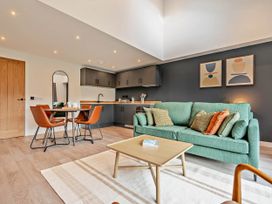 A living room with a sofa and dining area at Arvor Duplex 2.0 in Marhamchurch