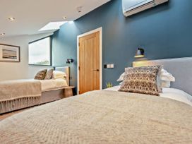 A bedroom with two beds and a window at Arvor Duplex 2.0 in Marhamchurch