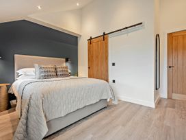 A bedroom with a bed and nightstand at Arvor Duplex 2.0 in Marhamchurch