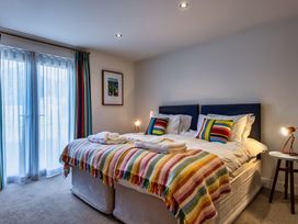 A bedroom with two beds and a lamp at Nettlecoombe Spa in Marhamchurch