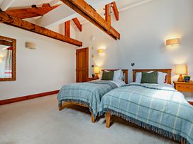 A bedroom with twin beds and wooden furniture at Jack's House in Marhamchurch