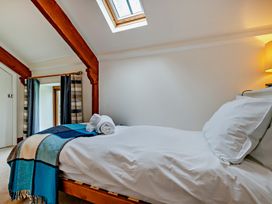 A bedroom with a bed and towels at Jack's House in Marhamchurch