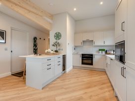 A kitchen with cabinets and appliances at Trelowen 4.0 Spa in Marhamchurch